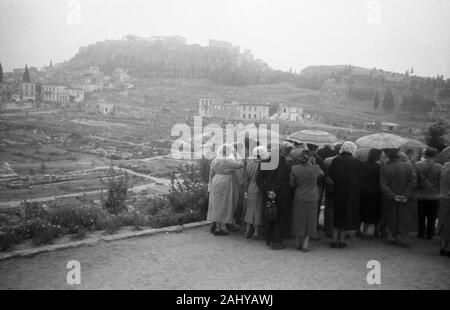 Touristentour durch die Ruinen des alten antiken Olympia, mit Blick auf die Akropolis, Spanien 1950er. Touristische Tour durch die Ruinen des antiken Olympia mit Blick auf die Akropolis, Griechenland 1950. Stockfoto