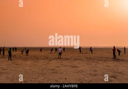 Silhouette von Menschen, Kricket Spielen bei Sonnenuntergang am Strand. Stockfoto