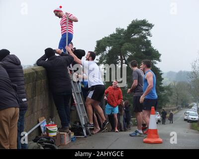 Mappleton (oder Mapleton) Brücke springen, jährlichen Tag der neuen Jahre Benutzerdefiniert. Teilnehmer gekleidet, wie Wo ist Wally aus springt Okeover Brücke und in Fluss Dove. Stockfoto