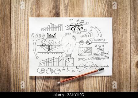 Business Infografiken Bleistift hand mit Gruppe von kommerziellen Doodles gezeichnet. Blick von oben auf die Arbeitsplatz mit Bleistift und Papier liegen auf Holzschreibtisch. Finanzielle Stockfoto