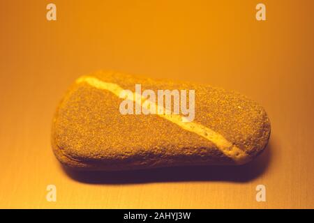Pebble Stone mit natürlichen Diagonale weiße Linie auf dem Tisch, Orange. Stockfoto