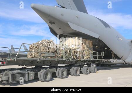 Flieger zu 43 Air Mobility Operations Group Verhalten laden Operationen auf C-17 Globemaster III Flugzeuge auf Papst Army Airfield, Nord-Carolina, Jan. 1, 2020 zugeordnet. Sie bei der Bereitstellung von Elementen der unmittelbaren Response Force unterstützt für die Bereitstellung des US Central Command Bereich Perations als Reaktion auf die erhöhte Bedrohung gegen den US-Personal und Einrichtungen mobilisiert. Die IRF und die All American Division bleiben posierten und bereit zur Unterstützung der nationalen Befehl Behörde bereitzustellen. (U.S. Armee Foto vom Kapitän Robyn J. Haake) Stockfoto