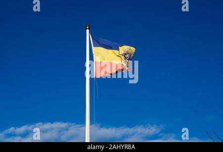 Wustrow, Deutschland. 30 Dez, 2019. Eine verschlissene Flagge von Mecklenburg mit dem Wappen der Motif ox Kopf weht vor einem blauen Himmel. Foto: Jens Kalaene/dpa-Zentralbild/ZB/dpa/Alamy leben Nachrichten Stockfoto