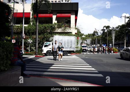 Quezon City, Philippinen - 27 Dezember, 2019: Fußgänger Überqueren einer Kreuzung mit fußgängerweg am Araneta Center in Cubao, Quezon City. Stockfoto
