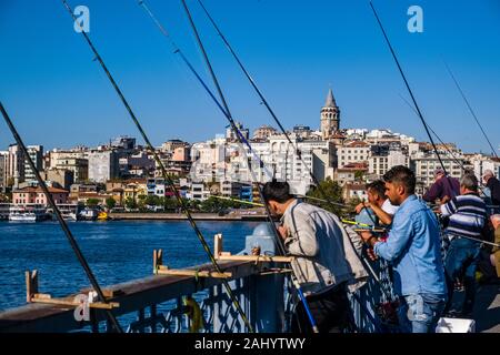 Männer sind die Fischerei auf der Galata-brücke, Galata Köprüsü, dem Vorort Karaköy mit der Galata Turm, Galata Kulesi über den Bosporus Kanal gesehen Stockfoto