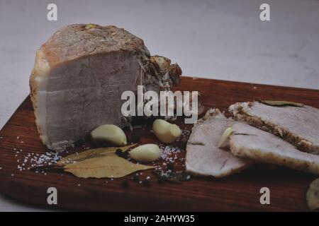 Gebackener Schinken mit Kapelle, Lorbeerblatt und Italienische Kräuter Stockfoto