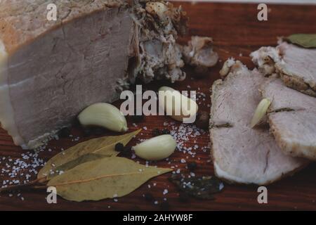 Gebackener Schinken mit Kapelle, Lorbeerblatt und Italienische Kräuter Stockfoto