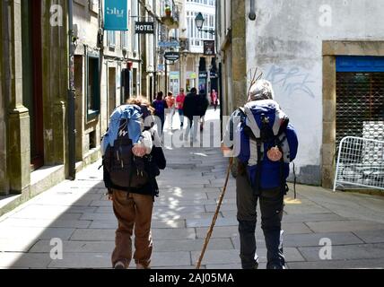 Pilger mit Jakobsmuschel, das Symbol des Camino de Santiago zu Fuß in der Altstadt. Santiago de Compostela, Spanien. Mai 5, 2019. Stockfoto