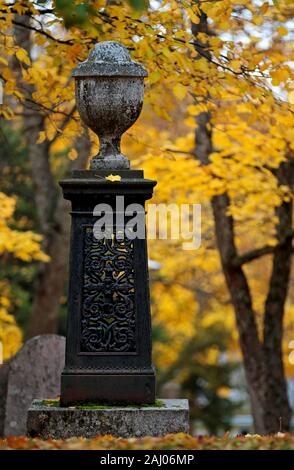 Ein altes Denkmal auf einem alten Friedhof mit schönen gelben Ahorn Bäume im Herbst Stockfoto