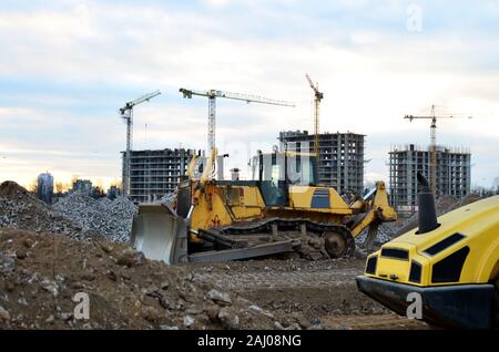 Anschluss - Typ Bulldozer auf der Baustelle. Flurbereinigung, Sortierung, Pool, Aushub, Grabenaushub und Fundament graben während der Großen konstruieren Stockfoto