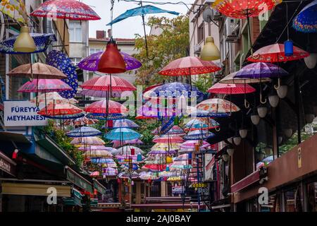 Colorfol Schirme hängen von Kabeln über eine kleine Straße im Stadtteil Karaköy Stockfoto