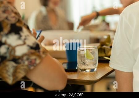 Gesunde Ernährung von Trinkwasser mit Schicht Kalk am Mittagstisch. Stockfoto