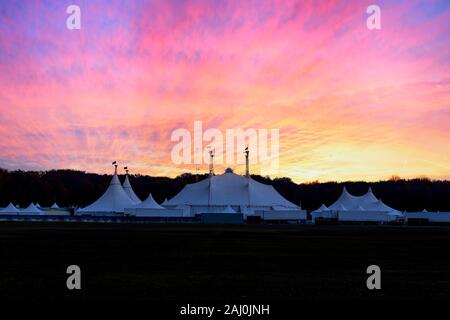 Zirkus Zelt unter einem warnen Sonnenuntergang und chaotischen Himmel, ohne den Namen des Zirkus Unternehmen, geklont wird und durch die metallische Struktur ersetzt Stockfoto