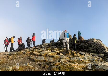 Wanderer auf dem Gipfel des Coniston Old Man am Silvesterabend, Lake District, Cumbria, Großbritannien Stockfoto