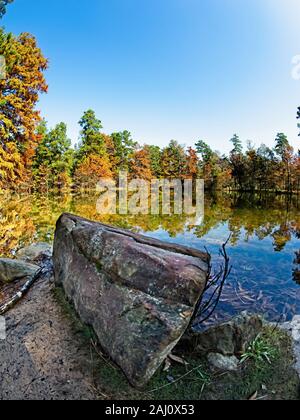 Conroe, TX USA - 11/15/2019 - Rock am See mit Fall farbige Bäume Stockfoto