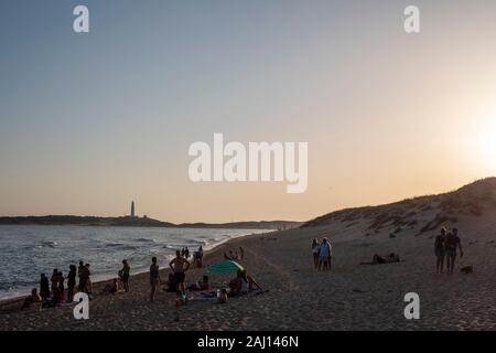 Die Leute am Strand von Caños de Meca, Costa de la Luz in Andalusien, Spanien gesammelt. Die Trafalgar Leuchtturm im Hintergrund Stockfoto