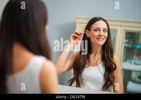 Junge Frau ist Reinigung Ohren im Bad. Stockfoto