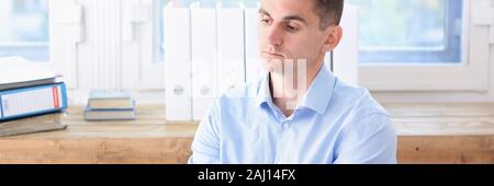 Unternehmer im blauen Hemd ist langweilig und traurig an Stockfoto