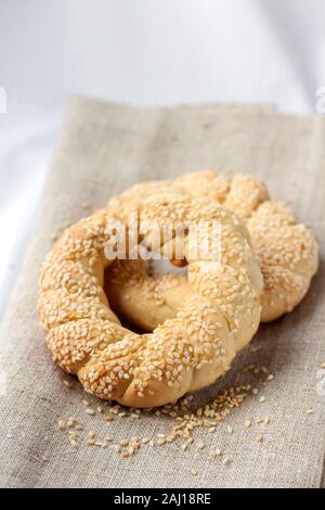 Türkische bagels Simits mit Sesam auf grauem Canvas. Simit ist ein rundes Brot, verkrustete mit Sesam, beliebt in den Ländern des Nahen Ostens. Stockfoto