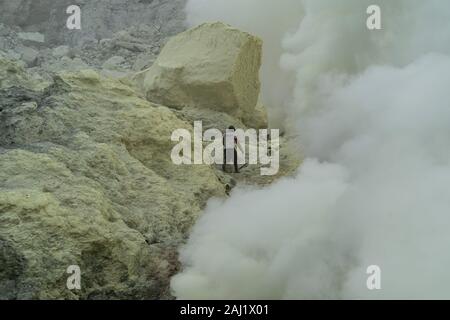 Klettern auf ein schwieriger Teil des Bergwerks eine indonesische Miner hofft, eine unberührte Quelle von Schwefel in der ijen Vulkan zu finden, Ost Java, Indonesien zu gelangen. 13/12/19. Stockfoto