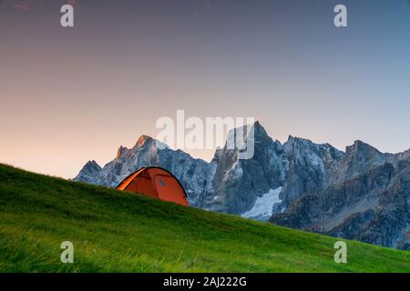 Sonnenaufgang über ein Zelt mit Blick auf den Piz Badile und Cengalo, Tombal, Soglio, Val Bregaglia, Kanton Graubünden, Schweiz, Europa Stockfoto