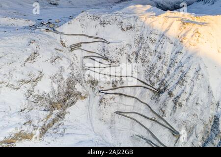 Enge Biegungen des Stilfser Joch Straße auf steile schneebedeckte Bergrücken, Luftaufnahme von Drohne, Provinz Bozen, Südtirol, Italien, Europa Stockfoto