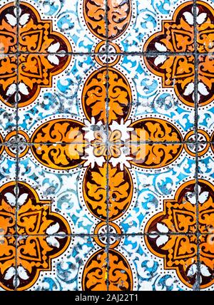 Portugiesische traditionelle Kacheln Azulejos mit blauen und orangefarbenen Blumenmuster auf einem weißen Hintergrund. Stockfoto