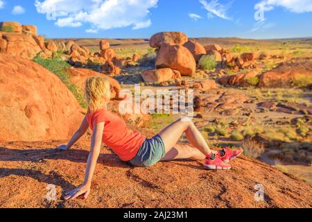 Touristische Frau auf Nyanjiki Lookout bei Sonnenuntergang bewundern Panoramablick und natürlichen Felsformationen bei Karlu Karlu (Devils Marbles), Australien Stockfoto