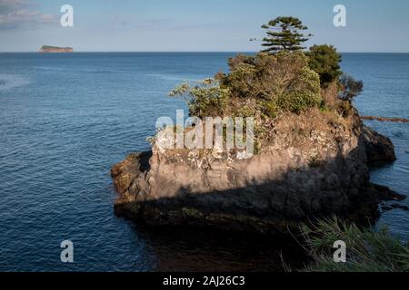 An der felsigen Küste des Atlantischen Ozean im Süden der Insel. Felsen mit Vegetation bedeckt. Blauer Himmel mit weißen Wolken im Frühjahr. Agua de Pau, Sao Mig Stockfoto