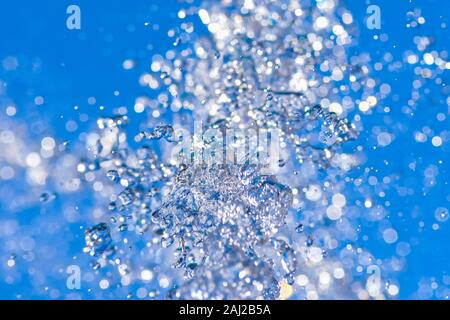 Die Wassertröpfchen Sprühen aus einem Brunnen in abstrakter Entwurf auf blauen Himmel Hintergrund und Detailreichtum und Kontrast. Konzept. Stockfoto