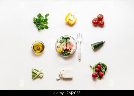 Vorbereitung griechischer Salat von frischem Gemüse, Schafskäse und Olivenöl. Oben Blick auf Sommer Salat in eine Schüssel und Zutaten. Das gesunde Essen. Stockfoto