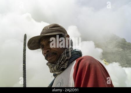 Dezember 11, 2019, Ijen, Indonesien: Ein indonesischer Bergmann kurz ruht nach einem hustenanfall in der Ijen Vulkans.. Die Ijen Vulkan ist einer der wenigen Orte, an denen Schwefel noch ohne Maschinen abgebaut ist, den Krater des Vulkans hat einen aktiven Schlot produziert, dass elementarer Schwefel. Atmung in den Schwefel Gas kann langfristige gesundheitliche Auswirkungen verursachen, aber trotzdem gibt es keinen Mangel an lokalen Bergleute riskieren alles, was ein gutes Gehalt zu verdienen ist, Bergarbeiter, einem durchschnittlichen Einkommen dreimal höher als die der lokalen Gehalt. Reiner Schwefel ist im Haushalt Reinigung Produkte verwendet, Make up, Sprengstoff und Pu Stockfoto