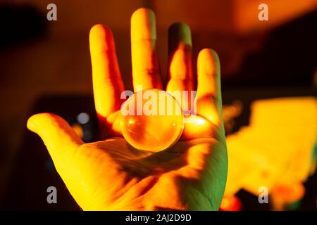 Nahaufnahme einer Hand mit einem Kristall Glas Kugel Kugel Transparent Stockfoto