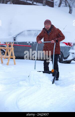 Winter und Schnee. man Schnee reinigt mit einer Schaufel Stockfoto