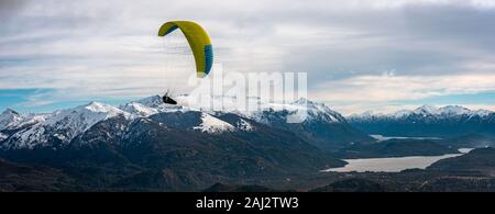 BARILOCHE, Argentinien, 19. JUNI 2019: Panoramablick über Paragliding über Nahuel Huapi See und Berge von Bariloche in Argentinien, mit verschneiten Spitzen Stockfoto