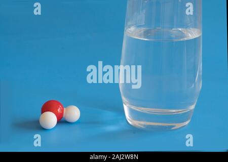 Glas von flüssigem Wasser und die H2O-Molekül mit einer Wasserstoff- und zwei Sauerstoffatomen. Stockfoto