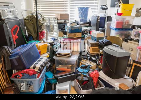 Vorratskäufer Zimmer mit Kästen, Elektronik, Geschäftsausstattung, Haushaltsgegenstände und sonstiges Junk verpackt. Stockfoto