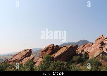 Große rote Felsformationen, ragt aus dem Boden, hinter Bäumen, auf der Trading Post Trail in Red Rocks State Park, Colorado, USA Stockfoto