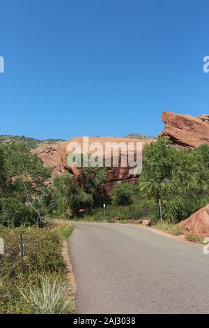 Red Rock Loop Road, gesäumt mit großen, roten Felsen, Bäume und Gräser in den Red Rocks State Park, Colorado, USA Stockfoto