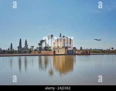 Der Menara mit weit entfernten Atlasgebirge und ein Flugzeug am Himmel Stockfoto