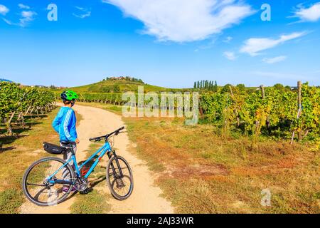 Elsass, Frankreich - Sep 18, 2019: Junge Frau Radfahrer stehen mit ihrem Fahrrad auf der Straße zwischen Weinbergen in der Nähe von Riquewihr, Elsass, Frankreich. Stockfoto