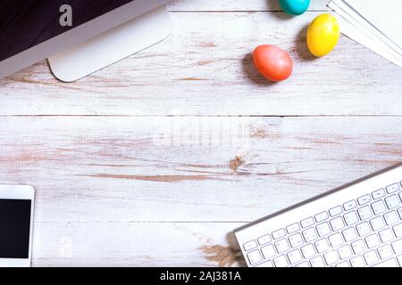 Business Schreibtisch mit Computer Telefon tastatur und happy Ostern bunte Eier Hintergrund auf eingerichtete weiße Holztisch moderne Feder de Stockfoto