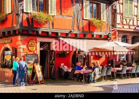 Elsass Wein Region, Frankreich - 20.SEPTEMBER, 2019: Die Menschen essen im Restaurant auf der Straße von Ribeauville Dorf, das auf der elsässischen Weinstraße, Franken befindet. Stockfoto