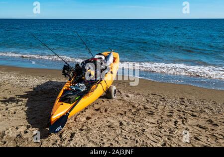 Orange Sea Kayak, Angelausrüstung und einen gefangenen Thunfisch auf Strand Cala de Mijas, Costa del Sol, Andalusien, Spanien. Stockfoto
