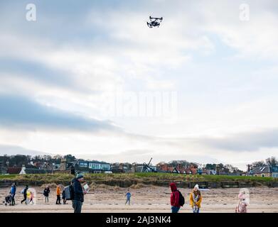Ein Mann, der eine Drohne illegal in einer Menschenmenge am Strand, West Beach, North Berwick, East Lothian, Schottland, VEREINIGTES KÖNIGREICH Stockfoto