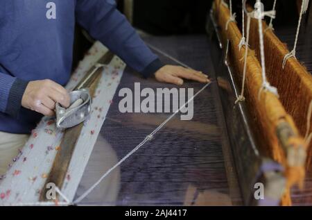 Gaza, Palästina. 2 Jan, 2020. Eine palästinensische Arbeiter webt Teppiche auf einem traditionellen Webstuhl an einem Teppich Fabrik in Gaza Stadt. Sprechen über alte Gaza, und was erscheint, sind die Bilder der Ton, bunte Glaswaren, Bambusmöbel und alten Rahmen Weben Webstühle helle Teppiche und Matten. Als solche Berufe sterben weltweit werden könnte, ist das Tempo ihrer sinkt zu schnell in Gaza, die sich aus der rund 500 Webstühlen, nur ein noch funktioniert. Credit: Mahmoud Issa/SOPA Images/ZUMA Draht/Alamy leben Nachrichten Stockfoto