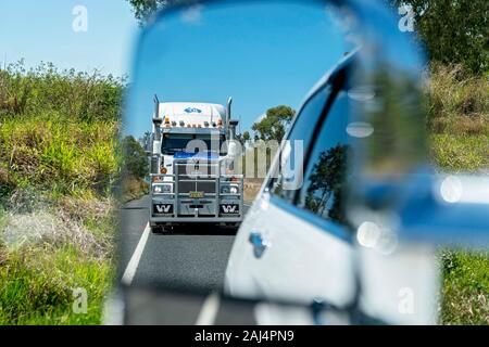 Waverley Creek, Queensland, Australien - Dezember 2019: ein Auflieger Lkw fahren auf der Autobahn als durch die hintere Vision Spiegel der Auto gesehen Ich Stockfoto
