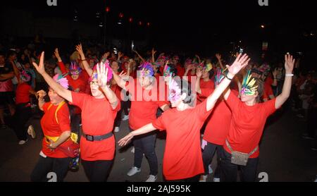 Eine Gruppe von Frau, tragen Masken und roten Hemden, Tanz in Chinese New Year Night Festival. Stockfoto