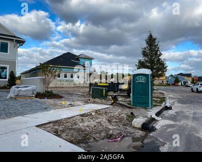 Orlando, FL/USA - 12/25/19: ein neues Haus, das im Bau mit einem Müllcontainer voller Müll und ein Porta Potty im Vorgarten. Stockfoto