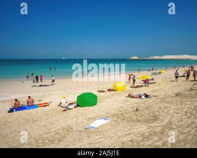 Dubai, VAE - Mar 16, 2013. Menschen Sonnenbaden am Jumeirah Beach in Dubai, und schwimmen im türkisblauen Wasser des Arabischen Golfs, die sich an einem sonnigen Tag. Stockfoto